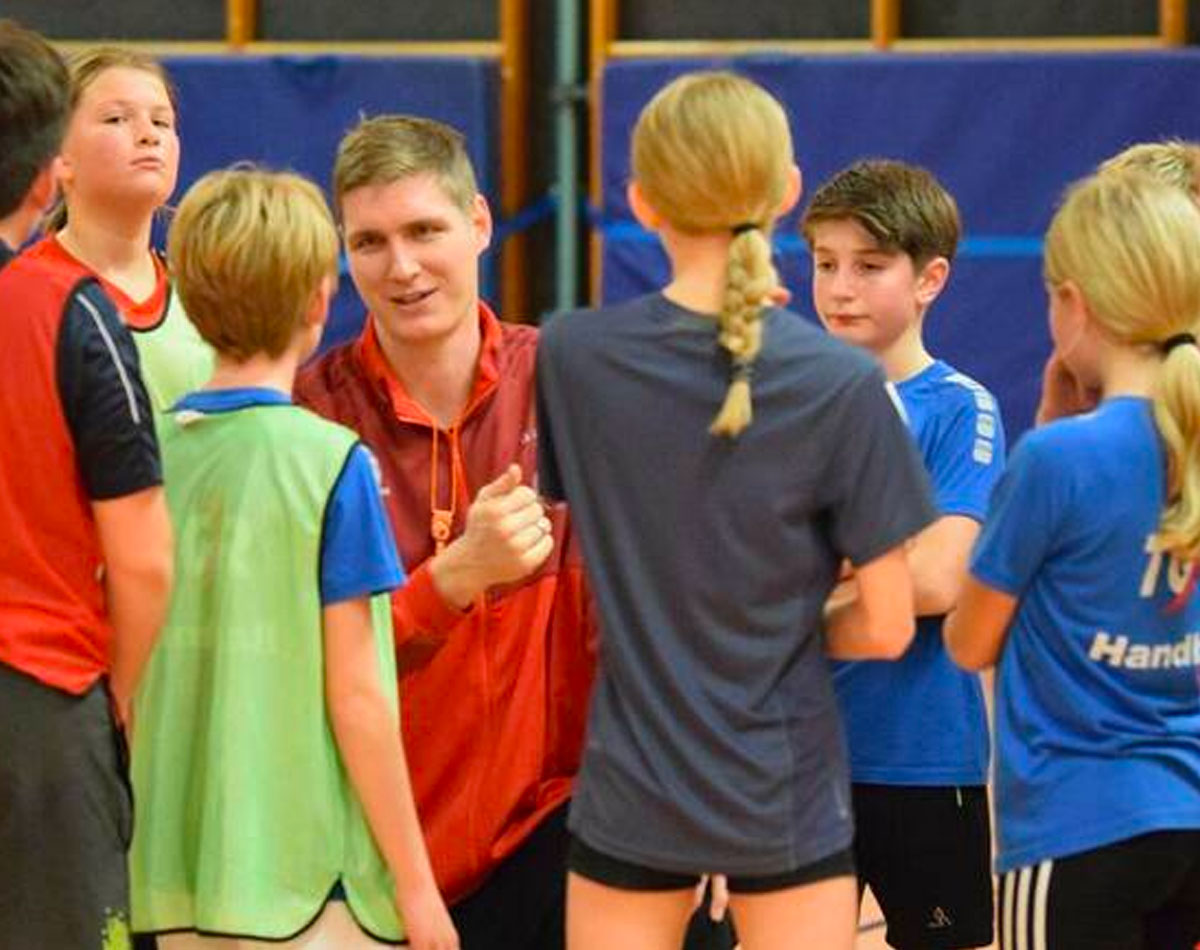 Auf Augenhöhe mit den Kids: Finn Lemke (Mitte) bespricht zum Abschluss das Training mit den D-Jugend-Handballern. Foto: Alicia Kreth